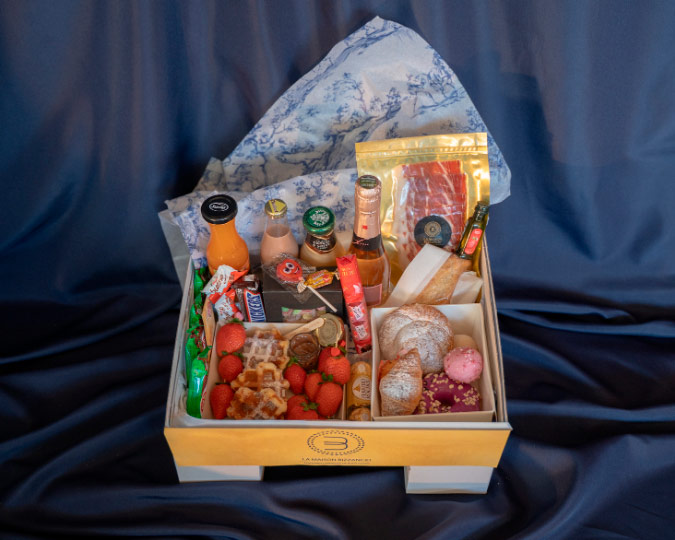 Pedestal Box Bizzancio presentada con su variedad de bollería gourmet, embutidos y bebidas, perfecta para desayunos a domicilio o regalos especiales.
