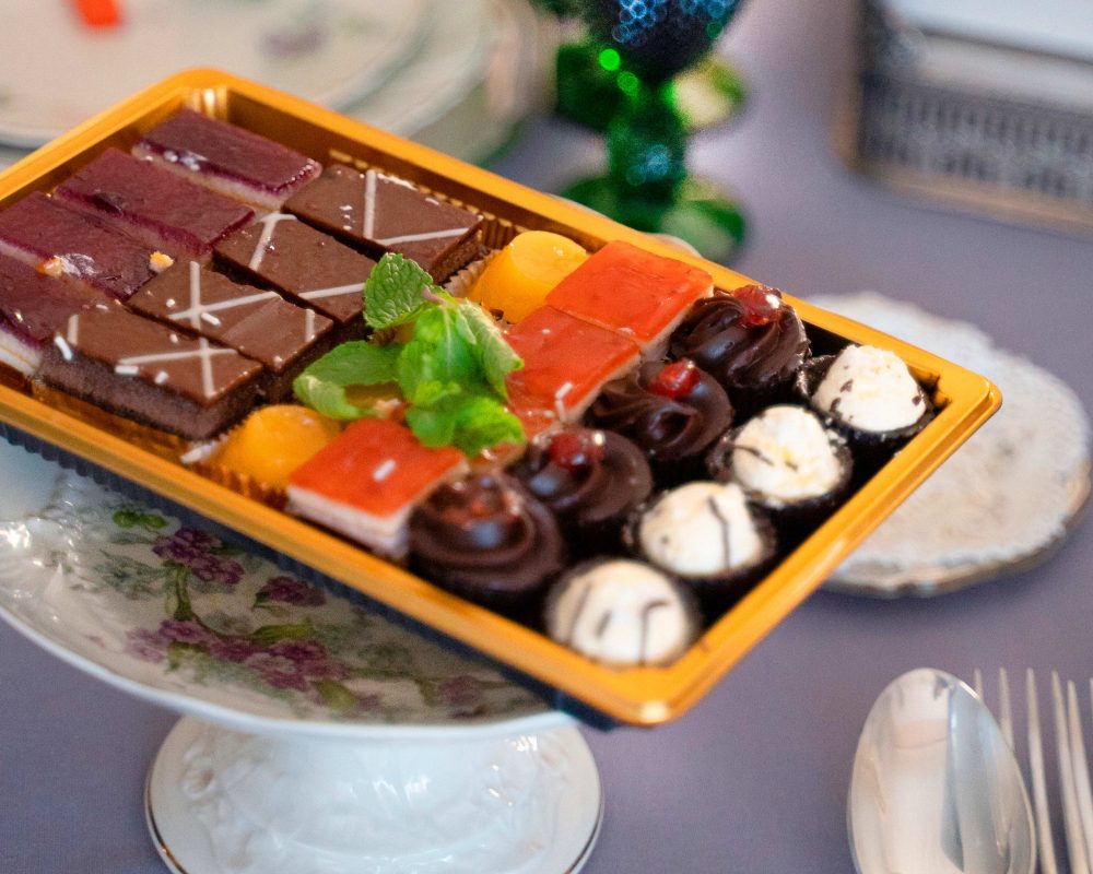 Detalle de la bandeja de postres de Bizzancio en mesa de comedor, mostrando dulces artesanales y presentación gourmet para desayunos a domicilio.