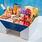Pedestal Box Bizzancio con botella extra de cava presentada con su variedad de bollería gourmet, embutidos y bebidas, perfecta para desayunos a domicilio o regalos especiales.