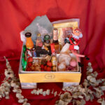 Pedestal Box Edición Navidad Bizzancio con bollería, charcutería y bebidas dulces, todo adornado con un elfo navideño y bastones dulces, ideal como desayuno a domicilio.