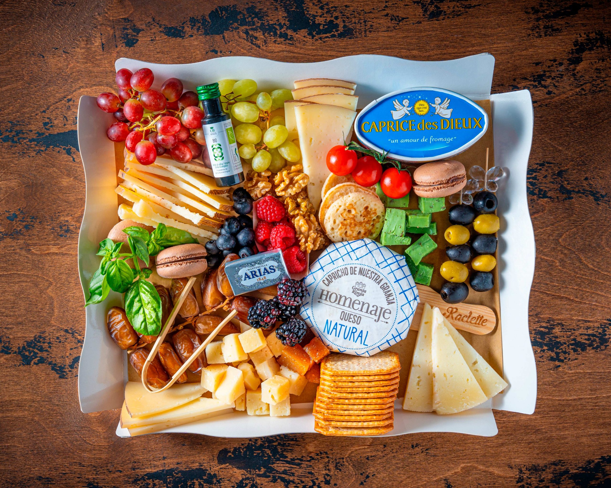 tabla-de-quesos-internacionales-bizzancio Tabla de Quesos Internacionales Bizzancio con uvas, frutos rojos y macarons en presentación gourmet, ideal como desayuno a domicilio.